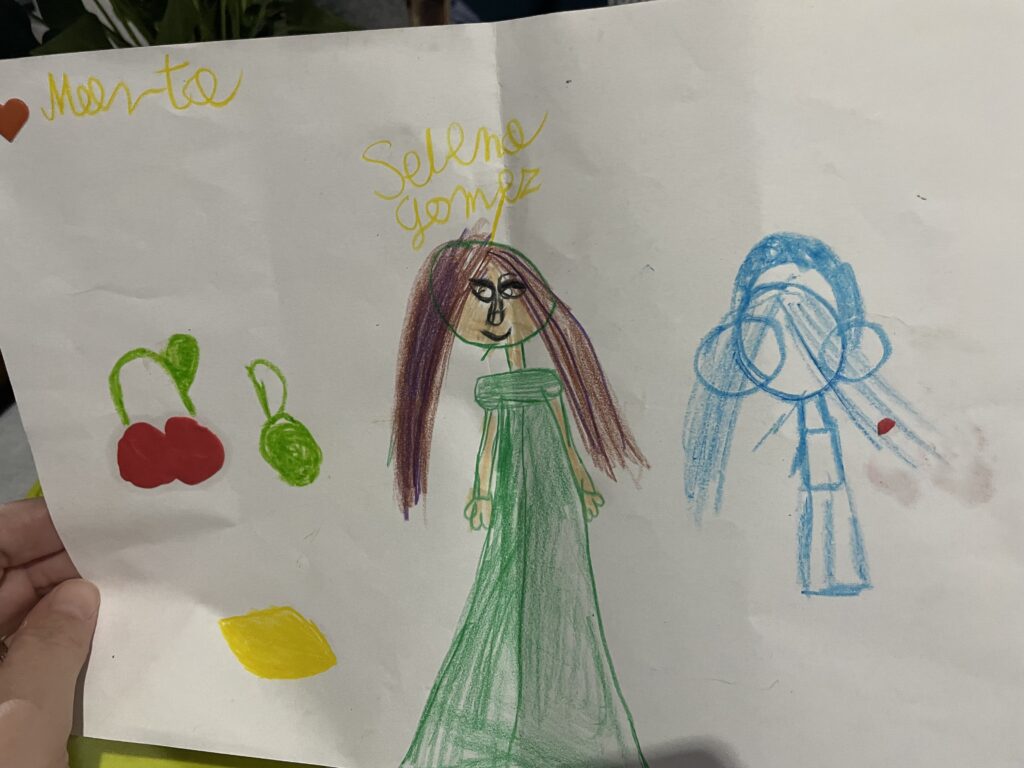 na zdjęciu jest obrazek namalowany krdekami przez Martę. dodane są podpisu, imię dziewczynki (marta) autorki obrazka, oraz Selena Gomez- ulubionej piosenkarki dziewczynki